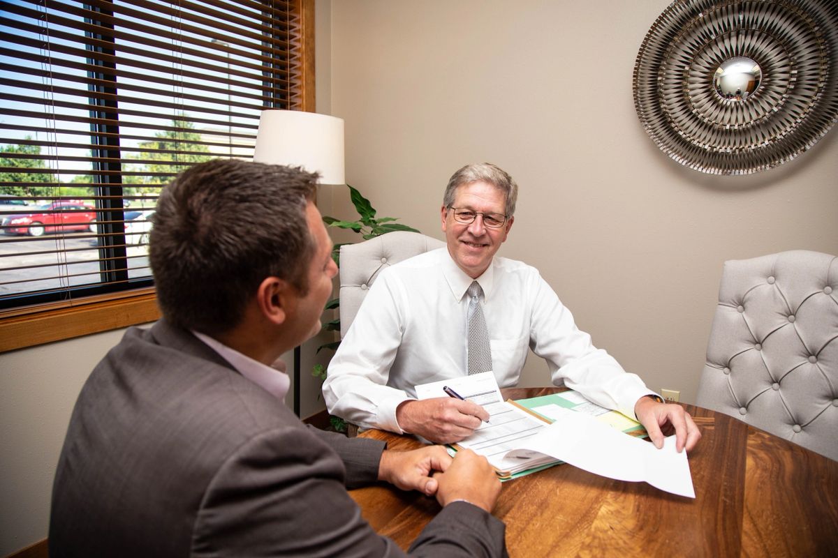 Mark Youngberg reviewing paperwork with a client in the Solus Real Estate office